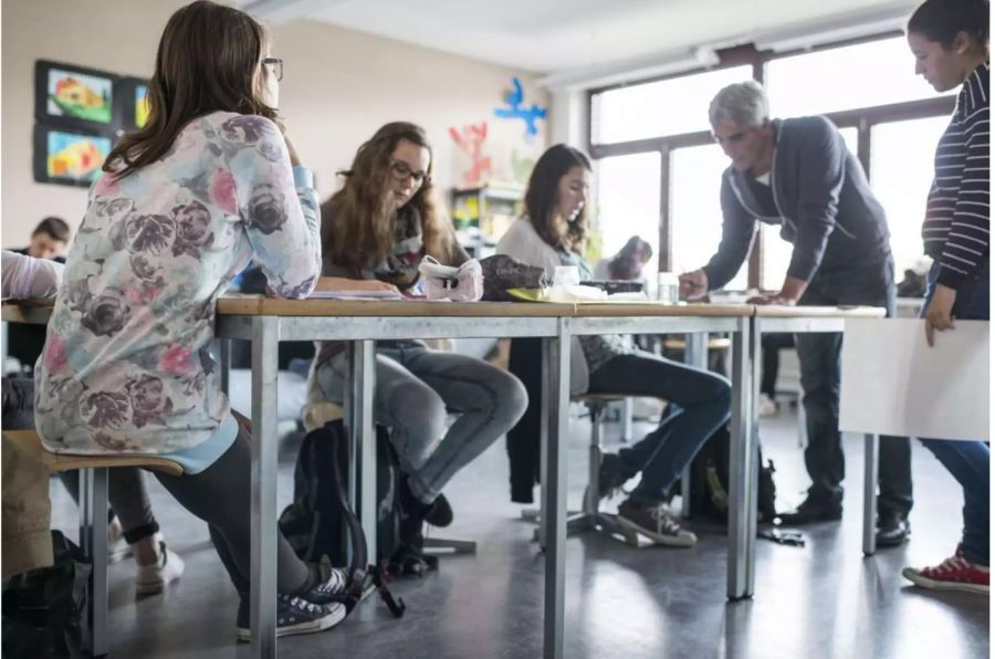 Ein Lehrer im Gespräch mit seinen Schülern und Schülerinnnen - Keystone