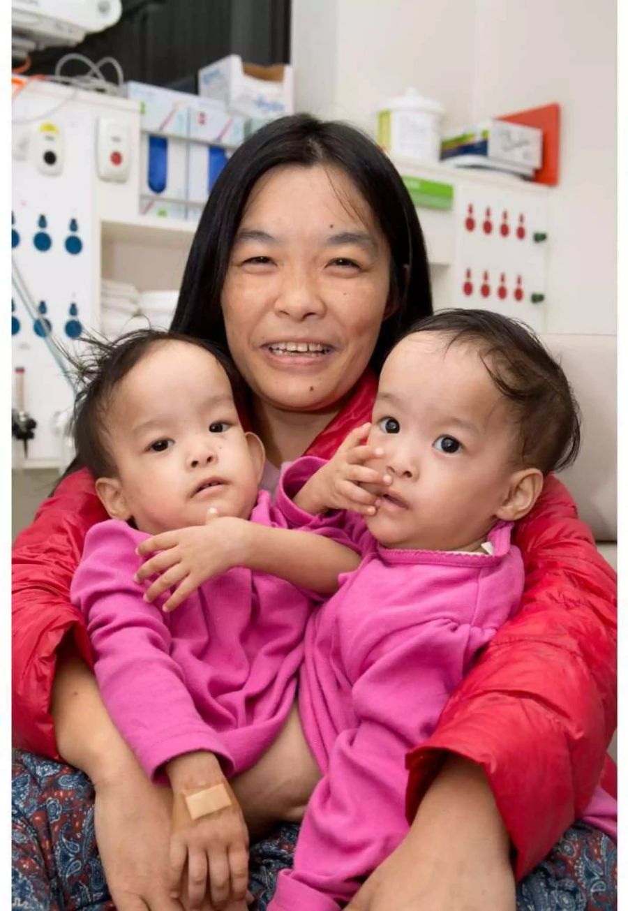 Die vierzehn Monate alten Nima (r) und Dawa (l) sitzen mit ihrer Mutter Bhumchu Zangmo im Royal Children's Hospital in Melbourne.