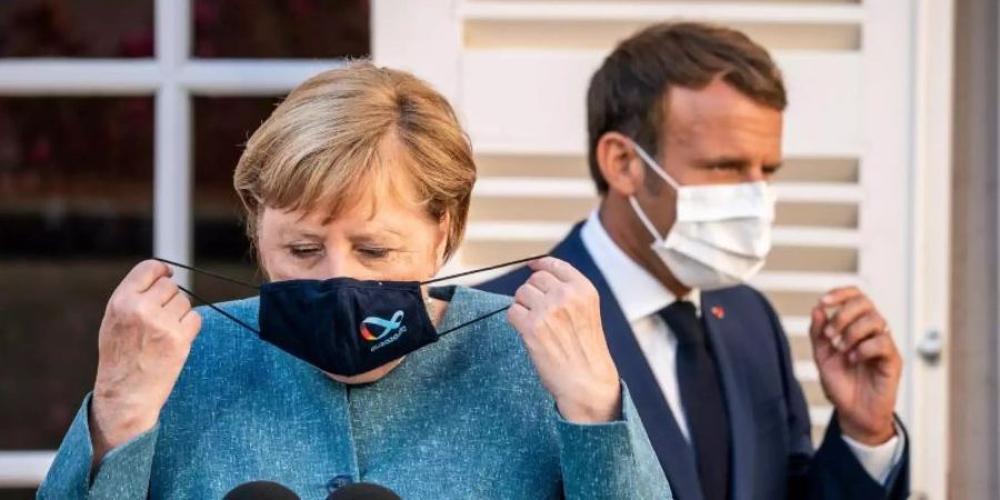 Der Bessere soll gewinnen: Bundeskanzlerin Angela Merkel (l) und Frankreichs Präsident Emmanuel Macron favorisieren natürlich verschiedene Teams im Finale. Foto: Michael Kappeler/dpa