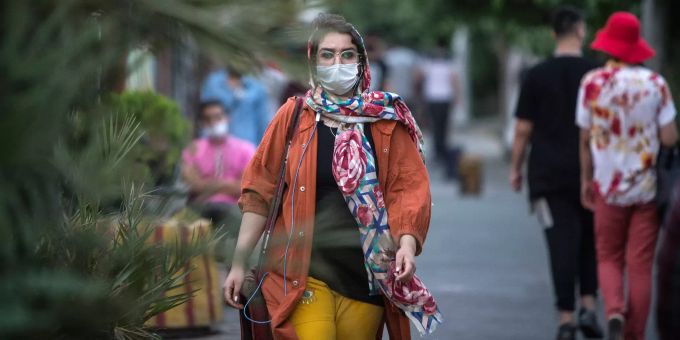 Eine Frau trägt beim Spazieren einen Mundschutz gegen das Coronavirus. Coronavirus - Iran