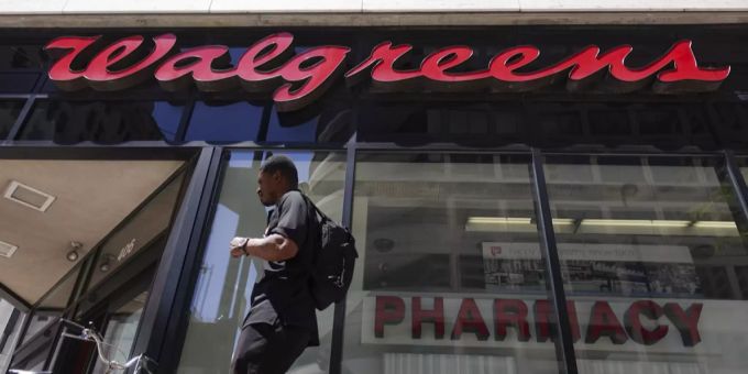 Ein Mann steht vor einer Walgreens Apotheke. Walgreens Boots alliance