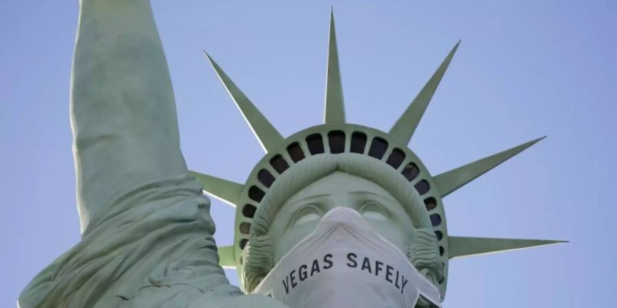 Eine riesige Maske ziert das Gesicht der Freiheitsstatue-Nachbildung in Las Vegas. Foto: John Locher/AP/dpa