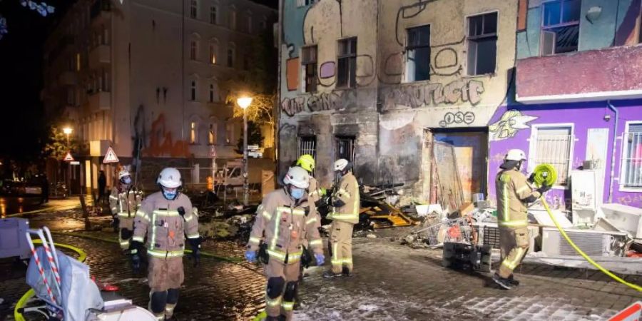 Feuerwehrkräfte sind vor dem geräumten Hausprojekt «Liebig 34» im Einsatz. Foto: Christoph Soeder/dpa