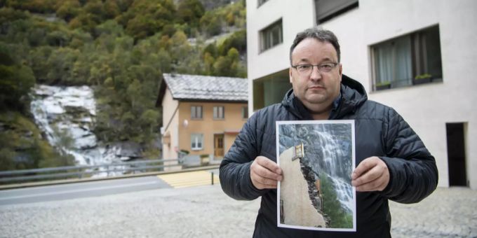 Roland Squaratti zeigt ein Bild der 2000 durch den Hangrutsch beschädigten Gemeindeverwaltung. Roland squaratti gondo