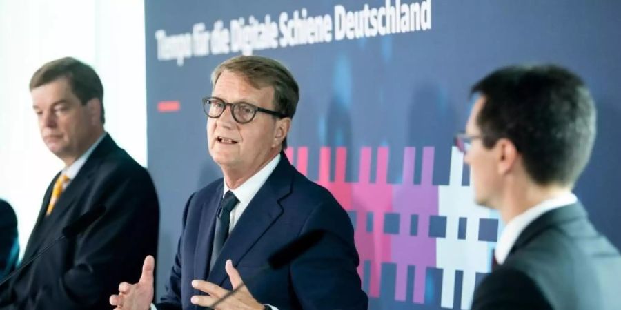Ronald Pofalla (M) äussert sich zusammen mit Enak Ferlemann (CDU, l), Parlamentarischer Staatssekretär im Bundesministerium für Verkehr und digitale Infrastruktur, und Andre Rodenbeck, Präsident des Verbandes der Bahnindustrie in Deutschland (VDB), zur Unterzeichnung eines «Memorandum of Understanding» zur Digitalisierung des Schienennetzes in Deutschland. Foto: Bernd von Jutrczenka/dpa