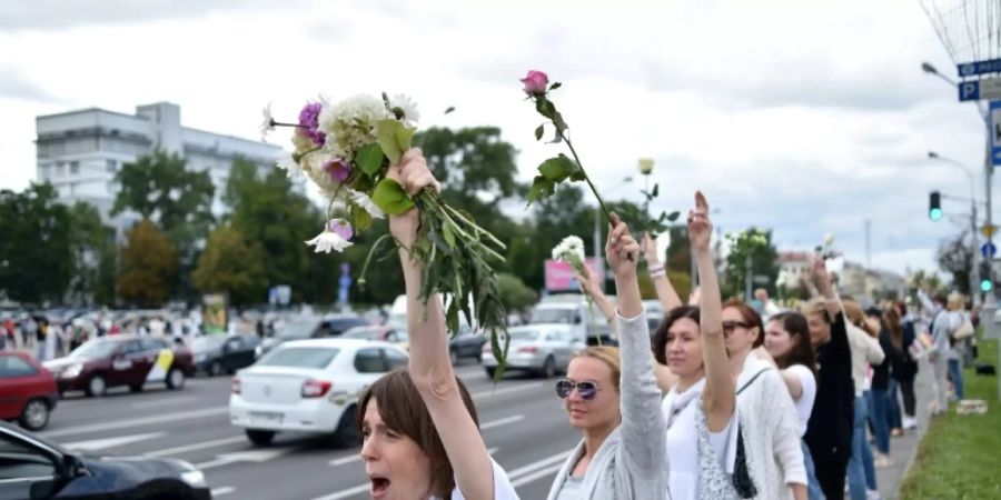 Weissgekleidete Demonstranten an einer Strasse in Minsk