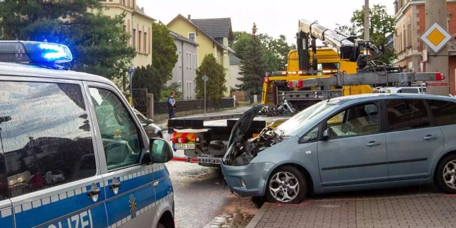 Das beschädigte Auto steht auf dem Gehweg. Foto: Daniel Schäfer/dpa-Zentralbild/dpa