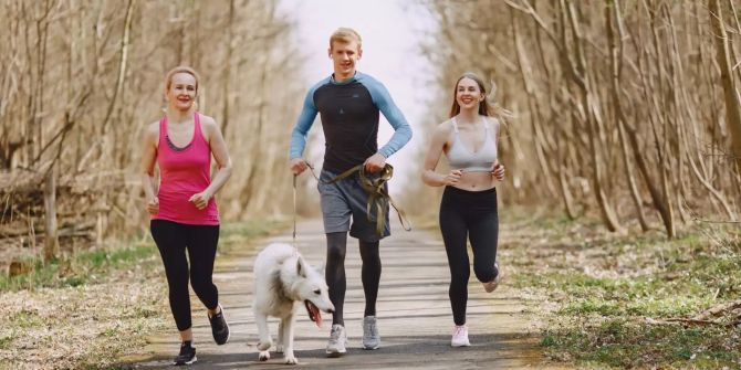 Drei Jogger mit Hund