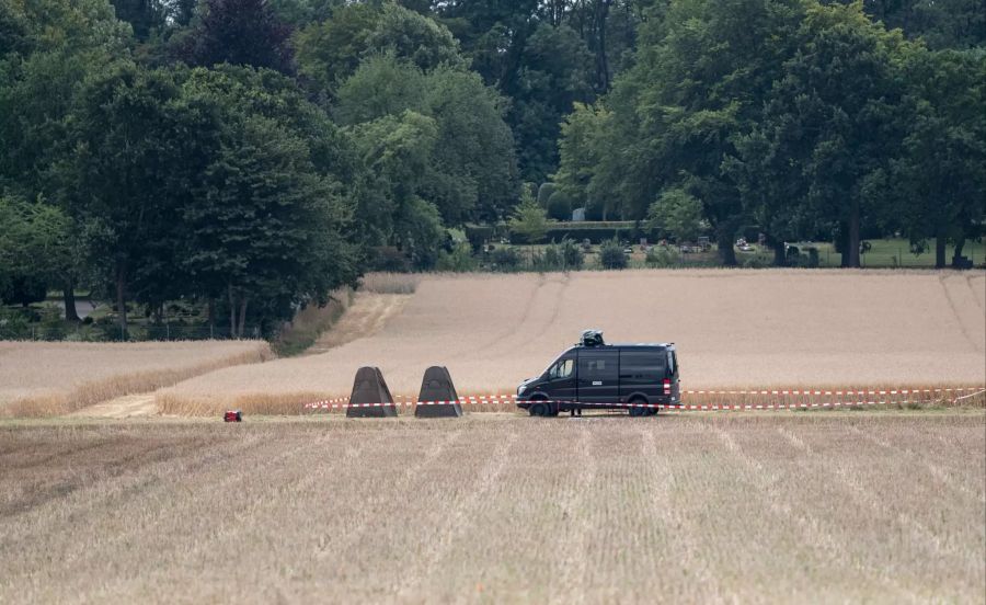 Niedersachsen, Seelze: Polizeifahrzeuge stehen vor einer Kleingarten-Parzelle, die von Beamten durchsucht wird