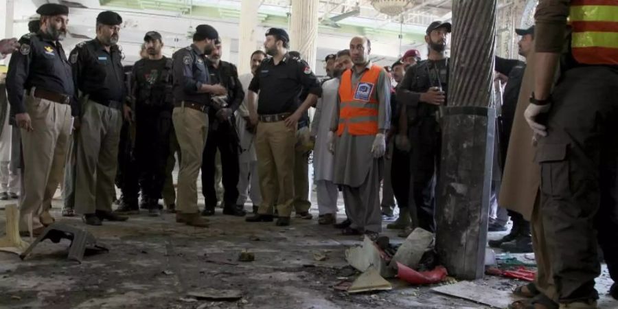 Polizisten stehen am Ort der Explosion in der Koranschule in Peshawar. Foto: Muhammad Sajjad/AP/dpa