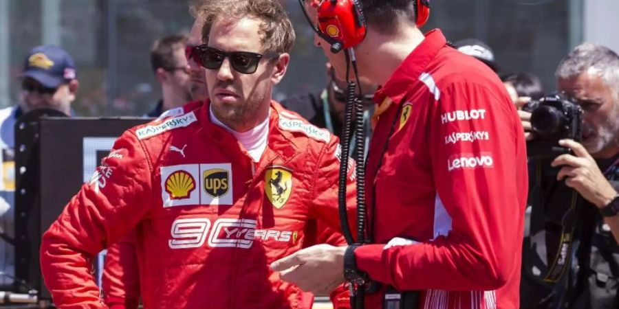 Fachgespräch: Sebastian Vettel (l) mit einem Techniker seines Ferrari-Teams. Foto: Paul Chiasson/The Canadian Press/AP