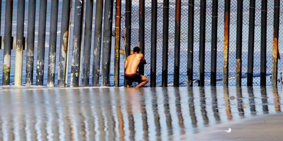 Unerreichbar: Ein Mann beobachtet durch den Grenzzaun bei Tijuana die amerikanische Seite. Foto: Alejandro Zepeda/EFE