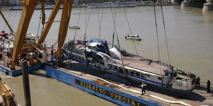 Ein Kran hebt das Schiffswrack des gesunkenen Ausflugsschiffs «Hableany» aus der Donau bei Budapest. Foto: Darko Bandic/AP