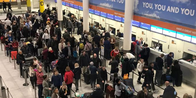 Passagiere warten auf den Check-in am Flughafen London-Gatwick. Coronavirus