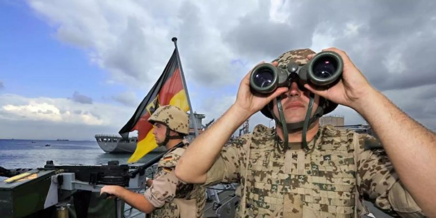 Deutsche Marine-Soldaten halten an Bord der Fregatte «Karlsruhe» an einem Maschinengewehr Wache. Foto: Gero Breloer/Archiv