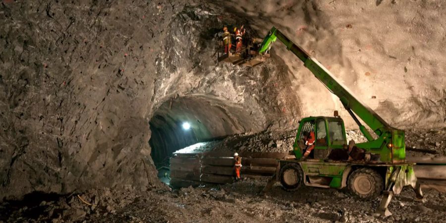Mineure auf einem Fahrzeugkran bereiten in der Weströhre des Gotthard-Basistunnels eine Sprengung vor.