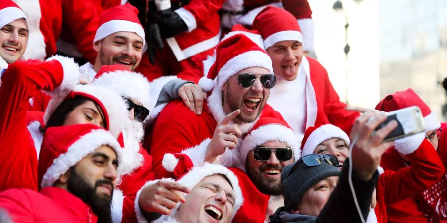 Teilnehmer der SantaCon NYC 2018 machen ein Selfie.