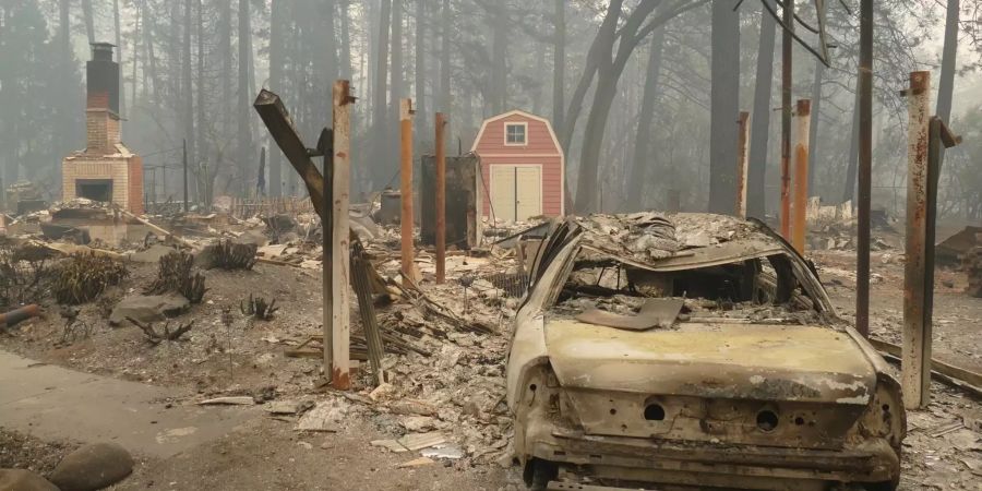 Ein ausgebrannter Pkw und Trümmer nach dem Waldbrand, dem sogenannten «Camp Fire» in Kalifornien.