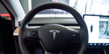 Auf dem Lenkrad des Elektroautos Model 3 von Tesla in einem Ausstellungsraum ist das Logo zu sehen