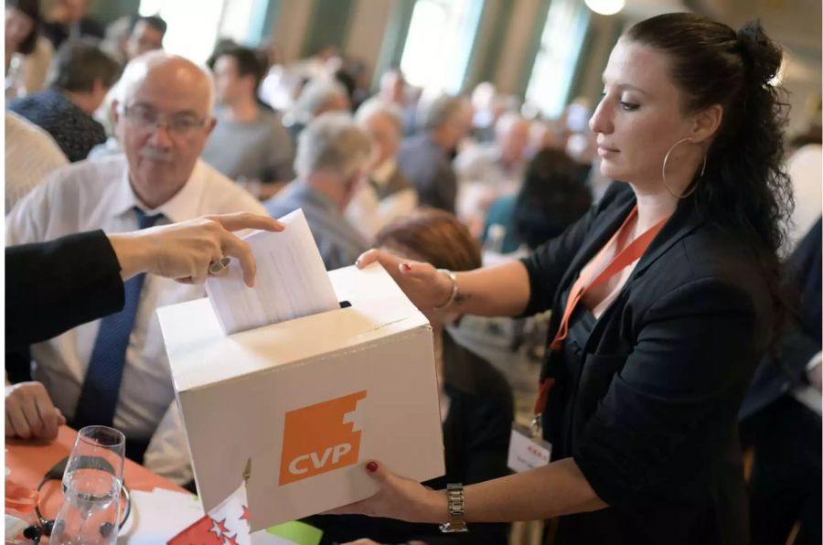 Frau sammelt mit CVP-Box Stimmbögen ein - Keystone