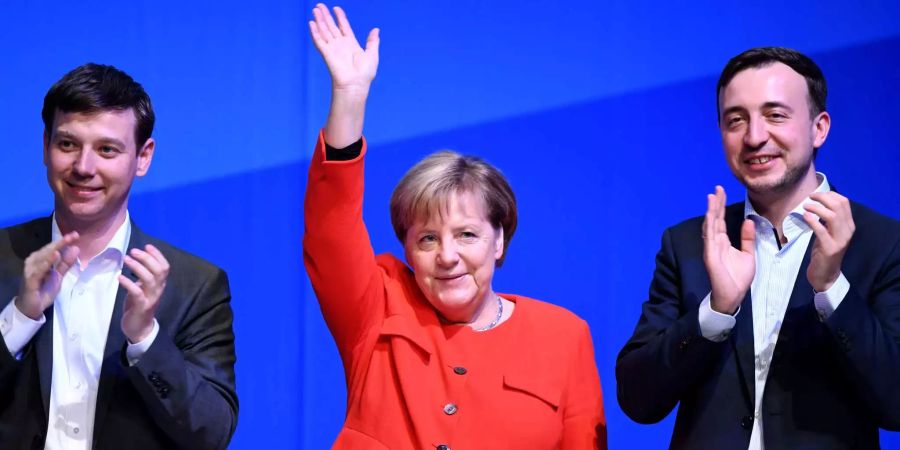 Bundeskanzlerin Angela Merkel steht beim Deutschlandtag der Jungen Union (JU) in der Sparkassen-Arena zwischen Tobias Loose (l), Landesvorsitzender JU Schleswig-Holstein, und Paul Ziemiak, Bundesvorsitzender der JU.