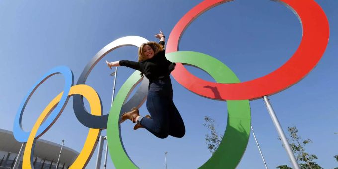 Eine Touristin lässt sich vor den Olympischen Ringen in Rio fotografieren (Symbolbild). Olympia Coronavirus