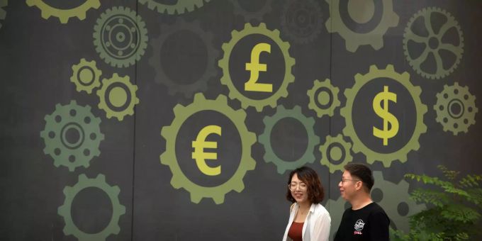 Der Handelsstreit mit den USA zeichnet sich in Chinas Wirtschaftswachstum ab. Menschen gehen an einer Wand vorbei.