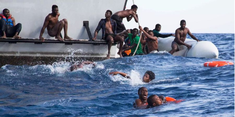 Migranten verlassen ein sinkendes Schiff.