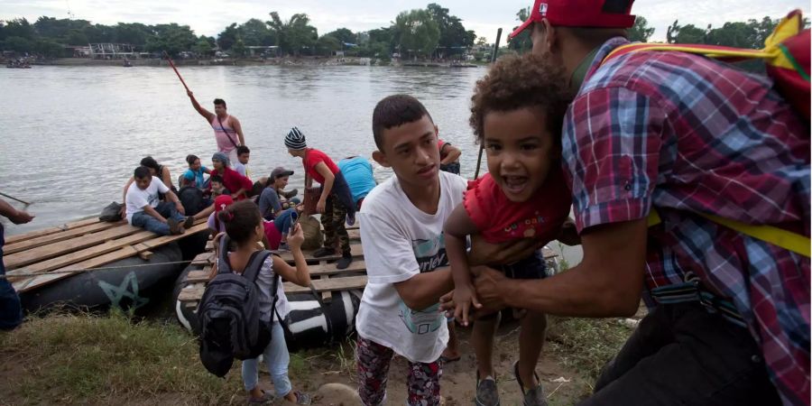 Migranten aus Honduras überqueren mit einem selbstgebauten Floss den Fluss Suchiate, der Guatemala und Mexiko verbindet.