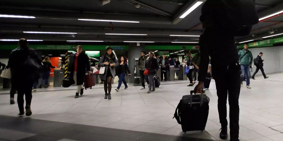 Menschen gehen während der Hauptverkehrszeit durch einen U-Bahnhof.