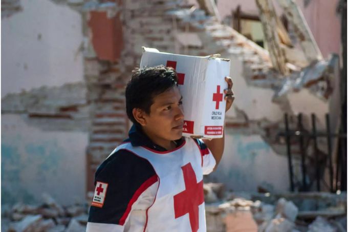 Ein Mitglied des Roten Kreuzes verteilt Hilfsgüter an Betroffene eines Erdbebens in Mexiko. rotes Kreuz