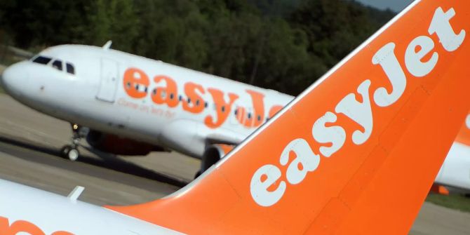 Ein Easyjet-Flugzeug rollt an eine andere Maschine heran.