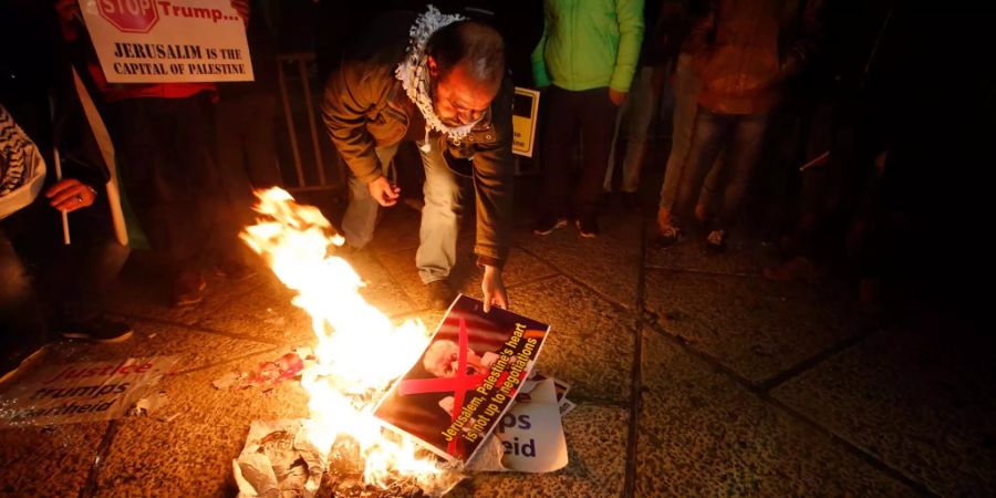 Während eines Protests in Betlehem verbrannte ein Palästinenser ein Poster von US-Präsident Trump.