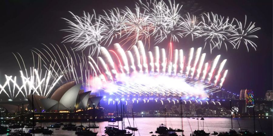 Raketen explodieren am 01.01.2018 in Sydney am Himmel beim Silvester-Feuerwerk über der Sydney Harbour Bridge.