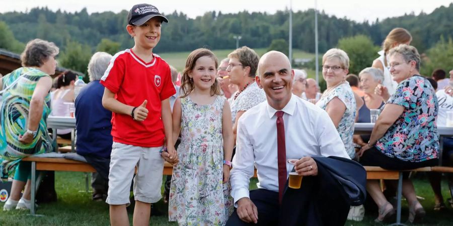 Bundespräsident Alain Berset posiert mit einem Buben und einem Mädchen in seinem Heimatort Belfaux, vor seiner 1. August Ansprache.