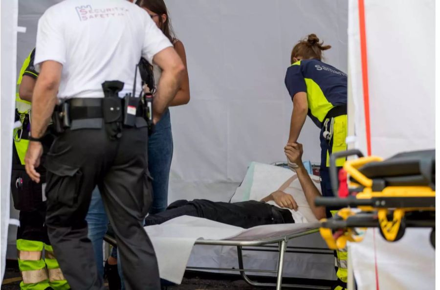 Sanitäter behandeln an der Street Parade in Zürich einen Besucher.