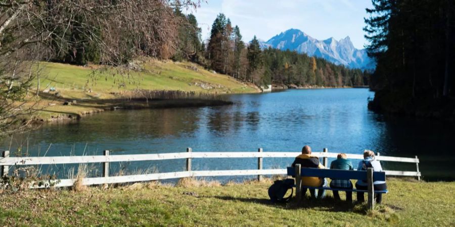 Menschen geniessen das Wetter am Chapfensee auf 1030 Meter über dem Meer, mit Blick auf Falknis, Schwarzhorn und Glegghorn.