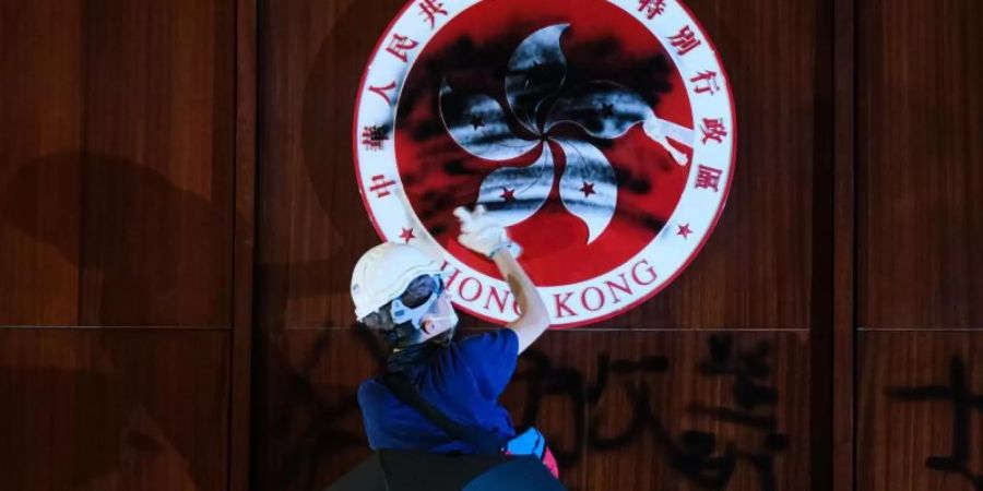 Im Hongkonger-Parlament, dem Gebäude des Legislativrats, schwärzt ein Demonstrant das Emblem der Stadt. Foto: Keith Tsuji/ZUMA Wire