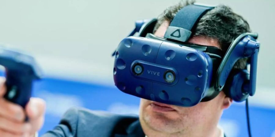 Hubertus Heil, Bundesminister für Arbeit und Soziales, probiert bei seinem Besuch des Chemiekonzerns BASF die Funktionsweise einer Virtual-Reality-Brille aus. Der Arbeitsminister ist auf Sommerreise. Foto: Uwe Anspach