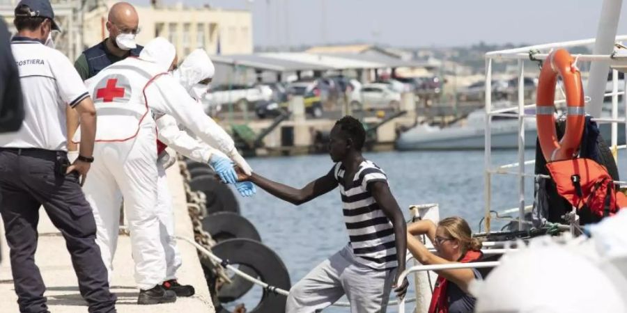 Migranten verlassen im Hafen von Pozzallo auf Sizilien ein Rettungsschiff. Foto: Francesco Ruta/ANSA