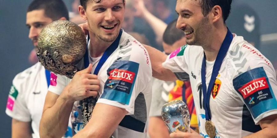 Christian Dissinger (l) will den Pokal nicht mehr aus der Hand geben. Foto: Marius Becker