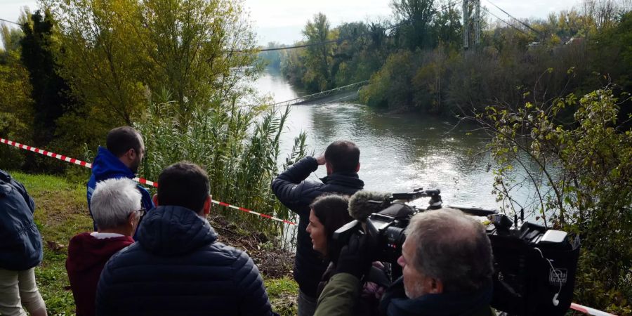 Reporter sehen sich die Unglücksstelle an.