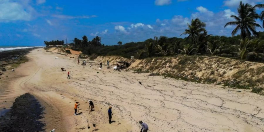 Freiwillige säubern den Strand von Ölrückständen