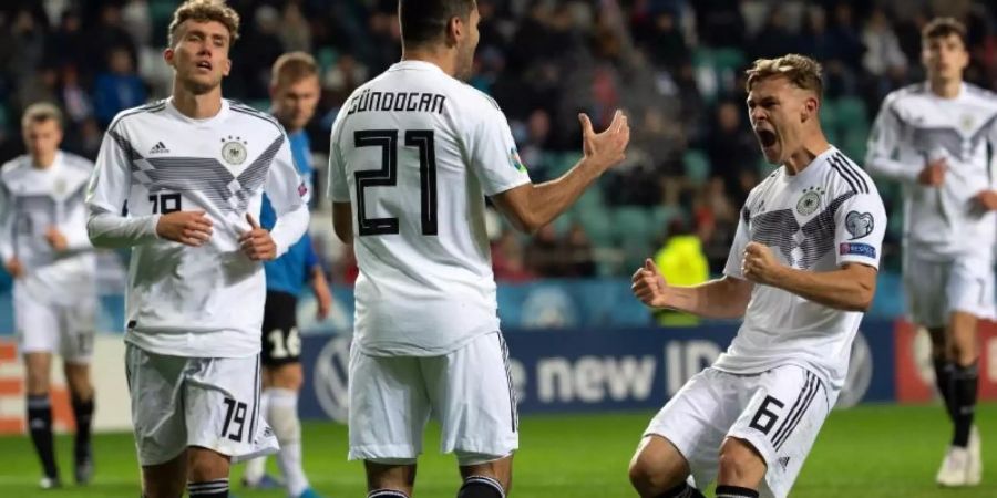 Ilkay Gündogan (M) feiert seinen Treffer mit Joshua Kimmich (r) und Luca Waldschmidt (l). Foto: Federico Gambarini/dpa