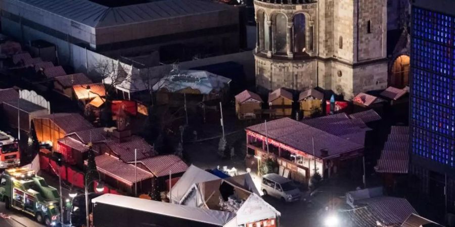 Eine Schneise der Verwüstung ist am 20. Dezember 2016 auf dem Weihnachtsmarkt am Breitscheidplatz in Berlin zu sehen, nachdem der Attentäter Anis Amri mit einem Lastwagen über den Platz gerast war. Foto: Bernd von Jutrczenka/dpa