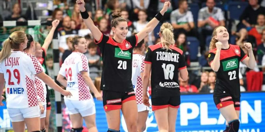 Deutschlands Emily Bölk (M-r), Mia Zschocke und Maren Weigel jubeln nach der ersten Halbzeit. Foto: Sina Schuldt/dpa