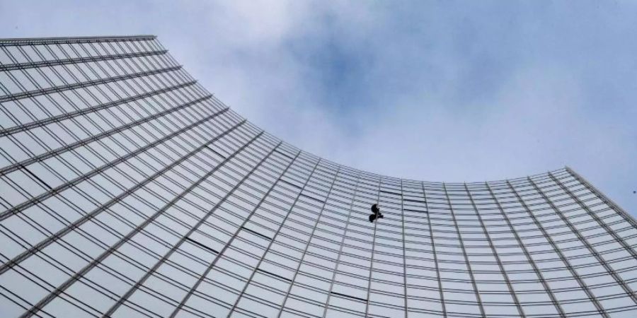 Nur ein kleiner, schwarzer Punkt: der Extremkletterer Alain Robert an der Fassade eines Frankfurter Hochhauses. Foto: Boris Roessler