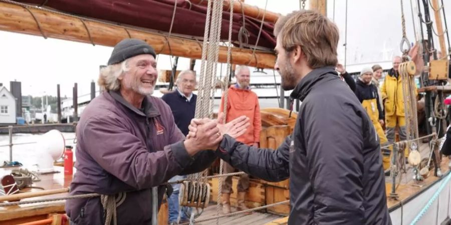 Der Polarforscher Arved Fuchs (l) begrüsst den Skipper Boris Herrmann, der die Klimaaktivistin Greta Thunberg über den Atlantik gebracht hatte. Foto: Magdalena Tröndle