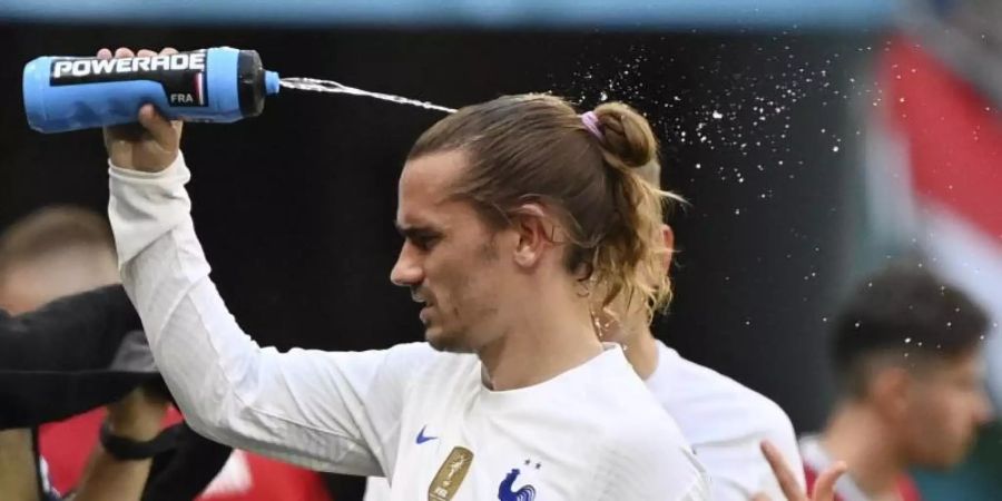 Frankreichs Antoine Griezmann spritzt sich zur Abkühlung Wasser auf den Kopf. Foto: Tibor Illyes/EPA Pool/dpa