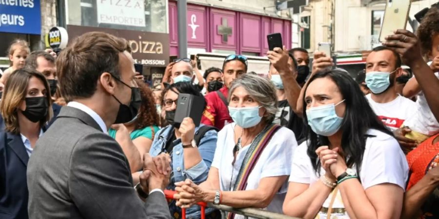 Macron (l.) trifft Schaulustige in Valence
